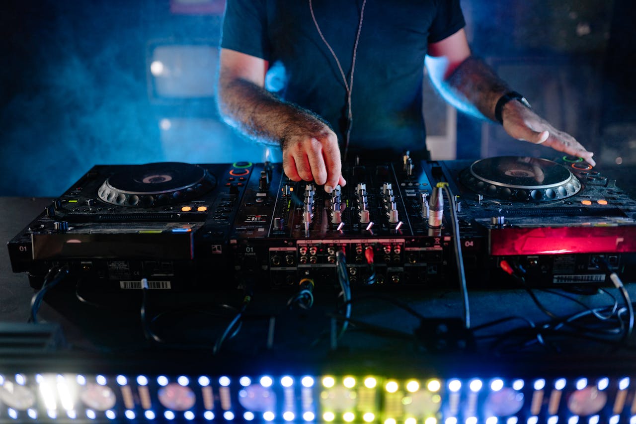 Man Playing Audio Mixer in Dark Room